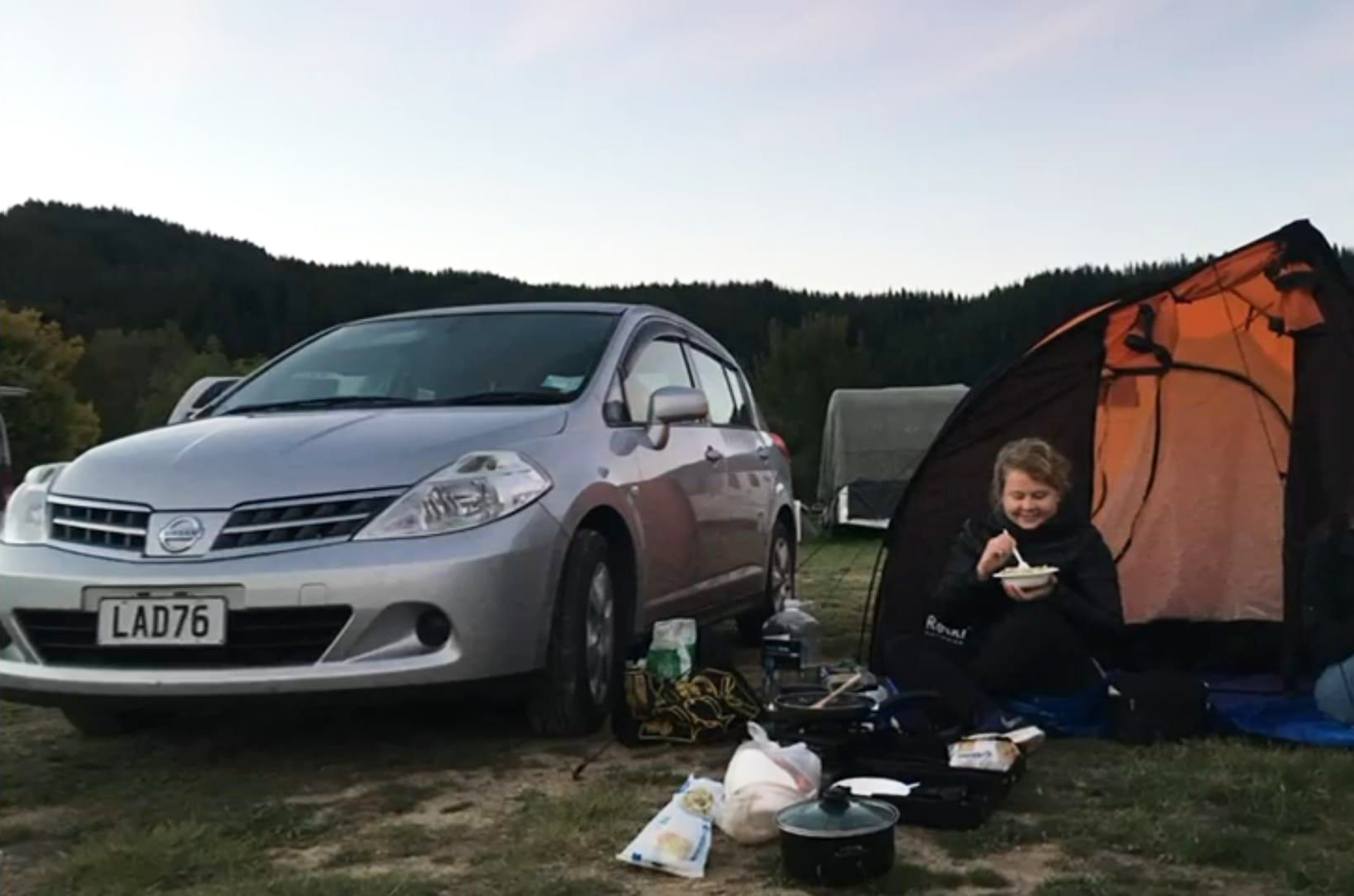 Uudessa-Seelanissa telttailemassa ja syömässä ruokaa teltan edessä.