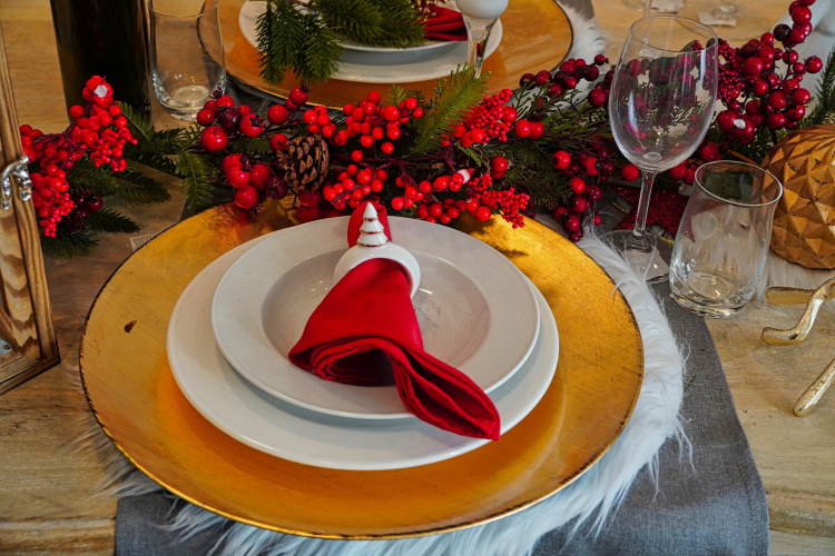 jouluisen juhla-aterian lautaset pöydällä, mansetin läpi punainen servetti 
