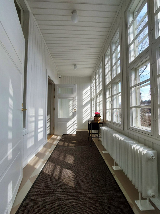 Pappilan avoimet ovet Kirkkoherranviraston sisäänkäynti pappilassa. Valo siivilöityy kauniisti ikkunoista.
