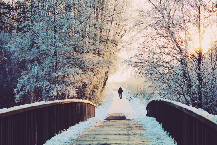 Mies yksin talvisella sillalla