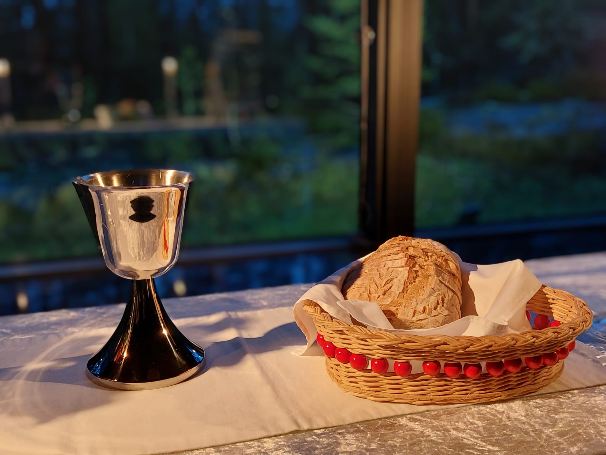 Ahvenlammen leirikeskuksen alttarilla on leipää ja viiniä.