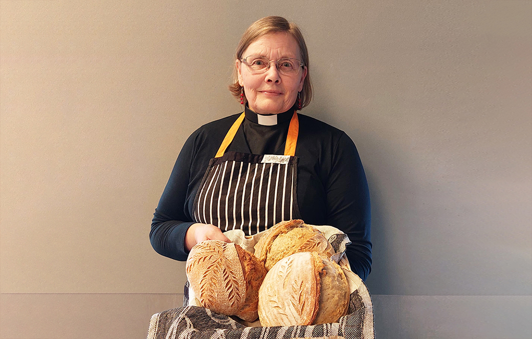 Rovasti, leipäpappi Päivi Laalo pitelee koria, joka on täynnä hänen itsensä leipomia leipiä.