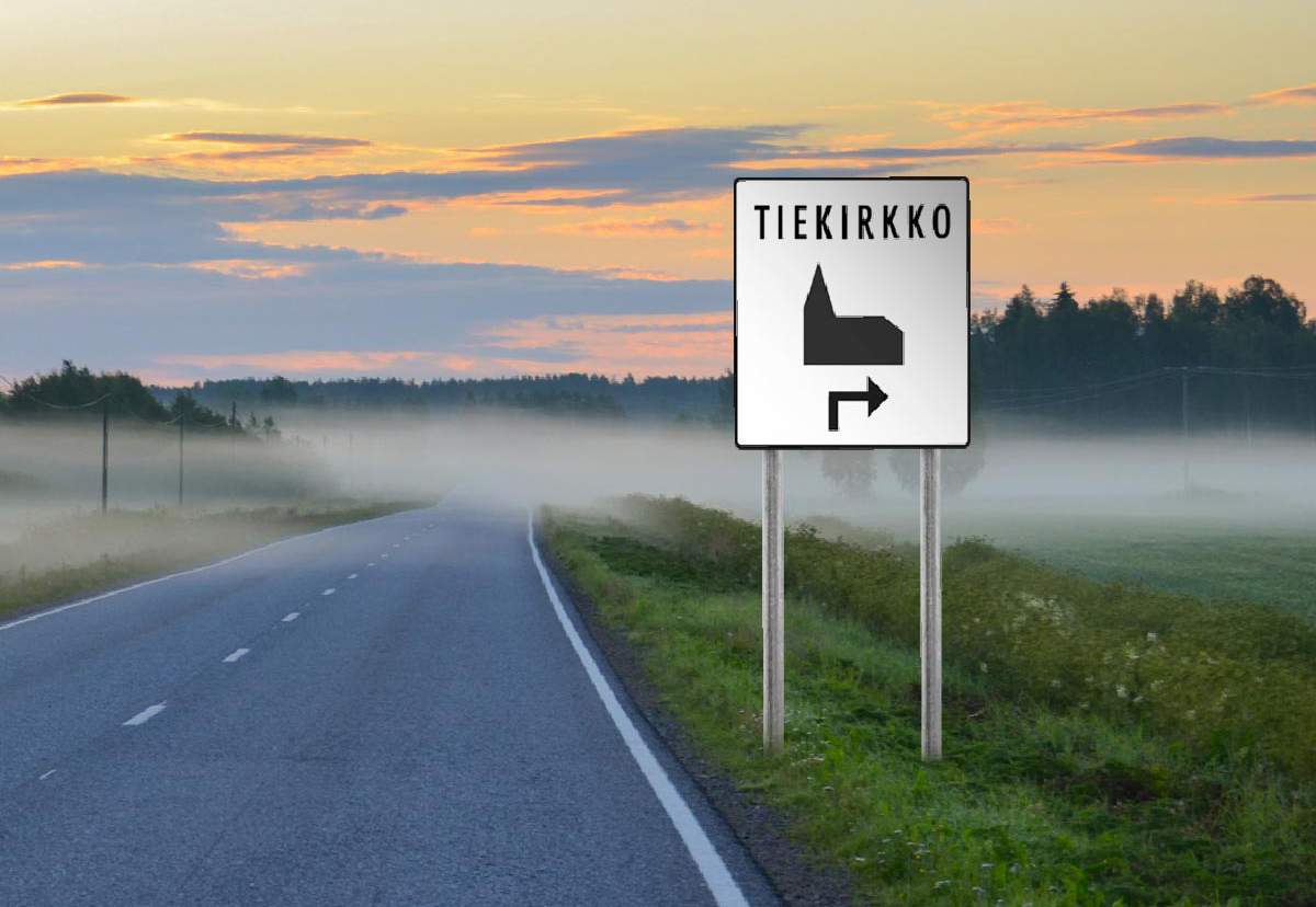 Tiekirkkokyltti usvaisen tien laidassa.