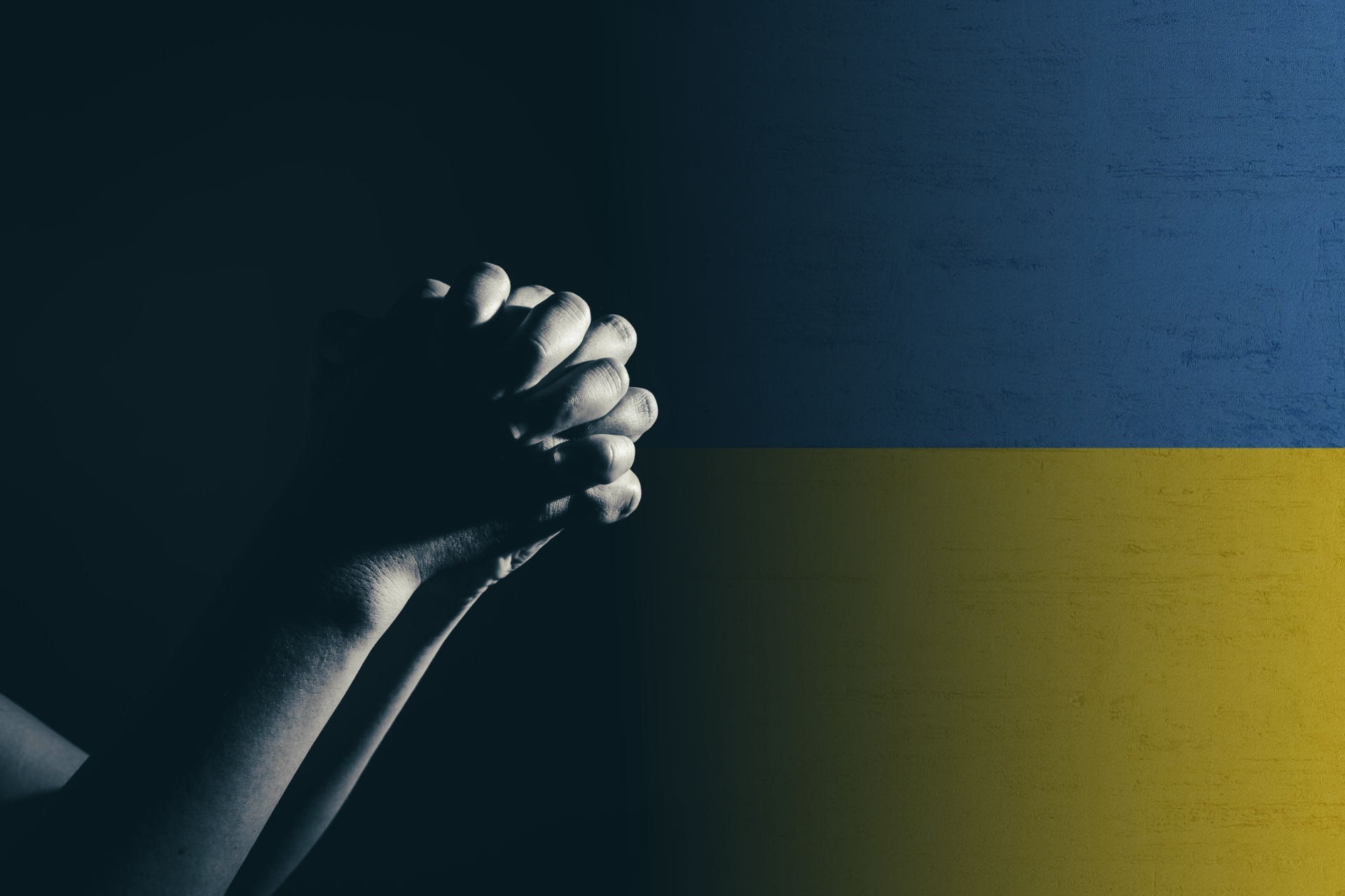 Ukrainan lippu taustalla ja sen edessä rukoilevat kädet.