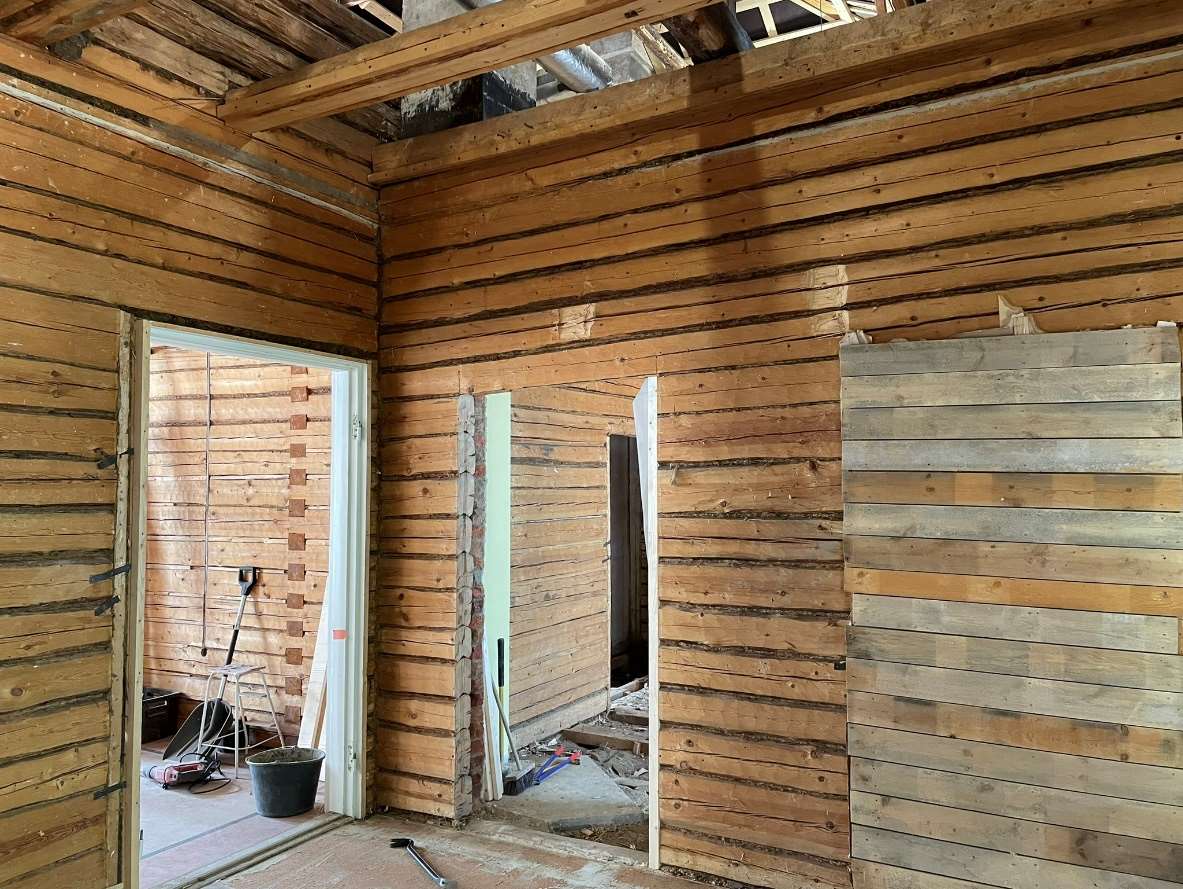 Seinäpintojen alta paljastuneita hirsirakenteita